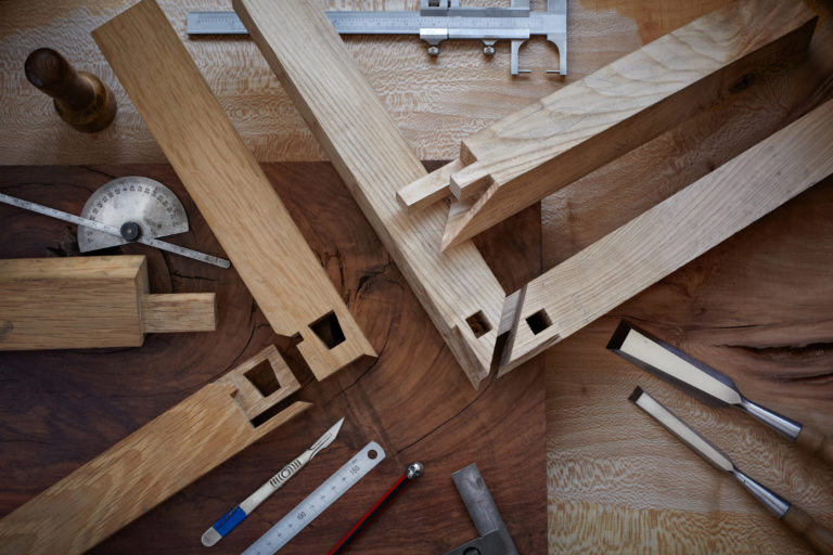 Overhead shot of intricate Japanese joinery and hand tools